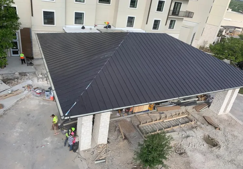 Metal roofing installation team working on a commercial building in Ashland